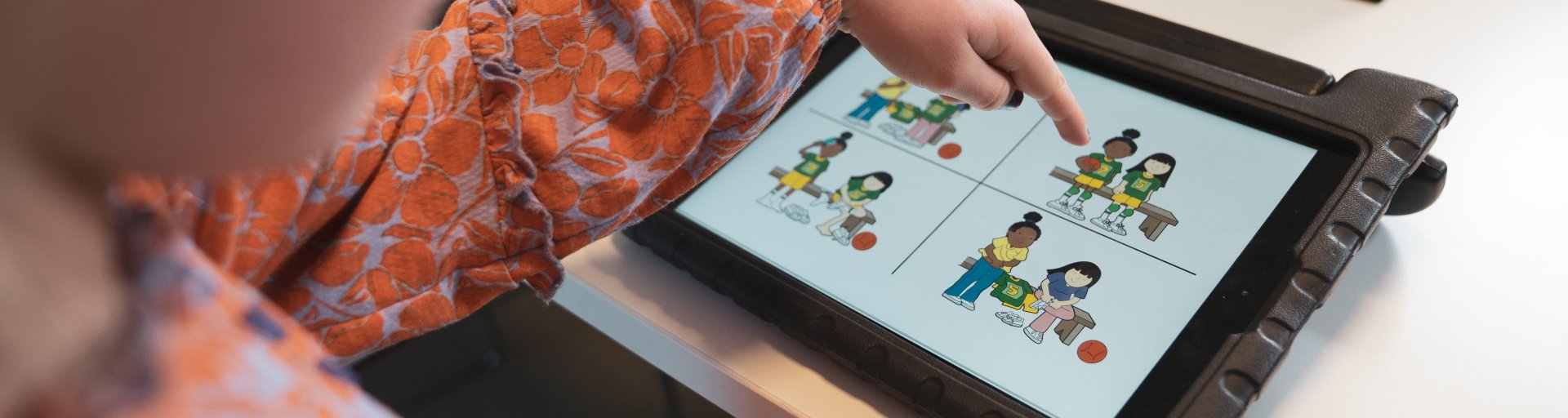 Kind wijst een plaatje aan op een tablet