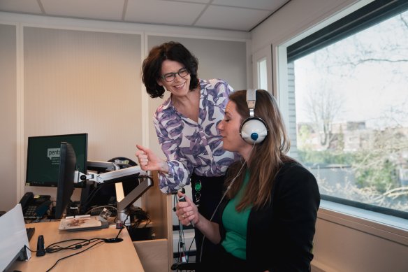 Vrouw met koptelefoon op voor gehooronderzoek